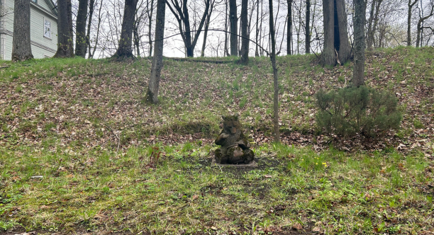 Parkā redzama statuja ar lāci un medus podu